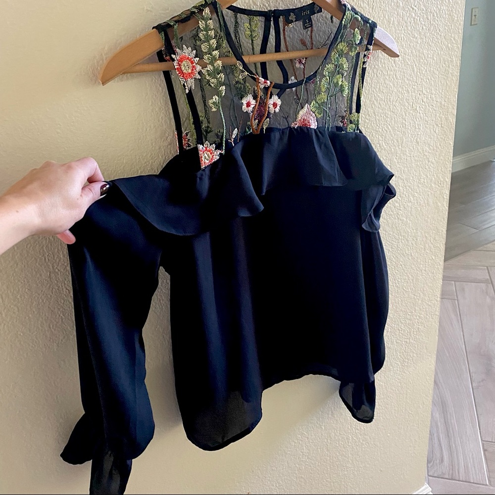 Small black long sleeve open shoulder ruffle blouse with floral embroidery